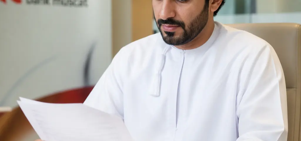 International Buyer Reviewing Swift Payment Documents For An Oman Property Purchase